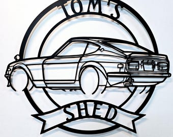 Könnte beinhalten: Schwarze Wandkunst aus Metall mit der Silhouette eines Oldtimers und dem Text "TOM'S SHED" in einem Kreis darum.