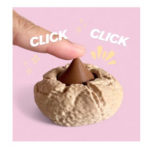 May include: A brown chocolate candy in a textured, beige-colored holder. The word "CLICK" is written twice in white, with a finger pressing down on the candy. The background is a soft pink.