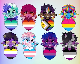 May include: A collection of colorful fairy keychains, each holding a heart-shaped flag representing different LGBTQ+ identities. The keychains feature various skin tones, hair colors, and styles. Text reads "Fairy Keychains" and "These and more!"