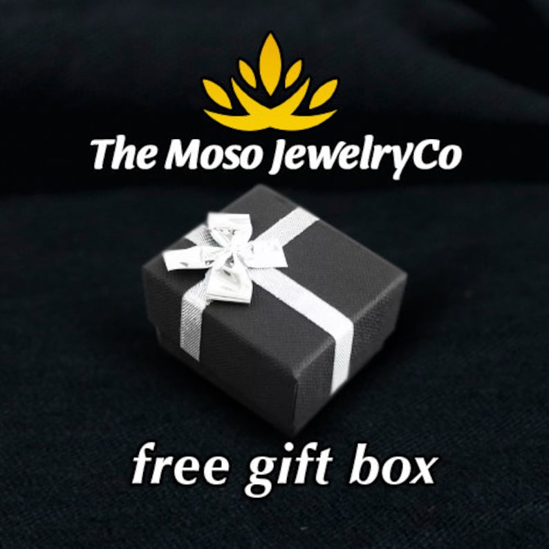 May include: A black gift box with a white ribbon and bow. The box is on a black background. The text "The Moso JewelryCo" is above the box. The text "free gift box" is below the box.