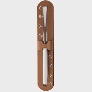May include: A wooden thermometer with a clear glass tube and a white tube. The thermometer has a brown wooden frame with white numbers indicating temperature from 0 to -15 degrees. The thermometer is designed to measure temperature.