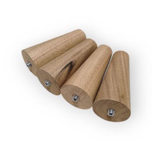 May include: Four wooden furniture legs with a conical design. Each leg is made of light brown wood and features a metal threaded insert for easy attachment. The legs are angled slightly, showcasing their shape and construction.