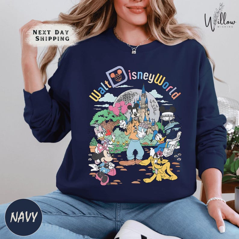 A woman wearing a navy blue sweatshirt with a colorful graphic of Disney characters and the text "Walt Disney World" printed on it.
