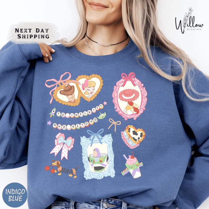 A woman wearing a blue sweatshirt with various cartoon-style illustrations and text on it.