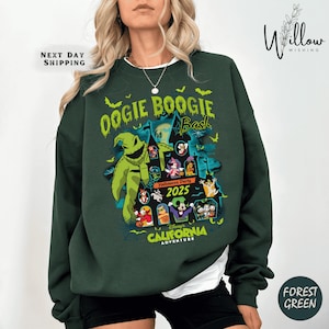 May include: Forest green sweatshirt with a graphic featuring the text "Oogie Boogie Bash" and "Halloween Party 2025." The design includes a cartoon Oogie Boogie character, Disney characters, and a haunted house. The words "California Adventure" are also visible.