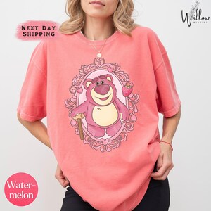 a woman wearing a pink shirt with a bear on it