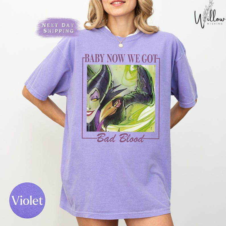 A woman wearing a purple t-shirt with a graphic design featuring a character from the Disney movie "Bad Blood".