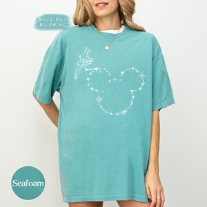 a woman wearing a blue shirt with a heart on it