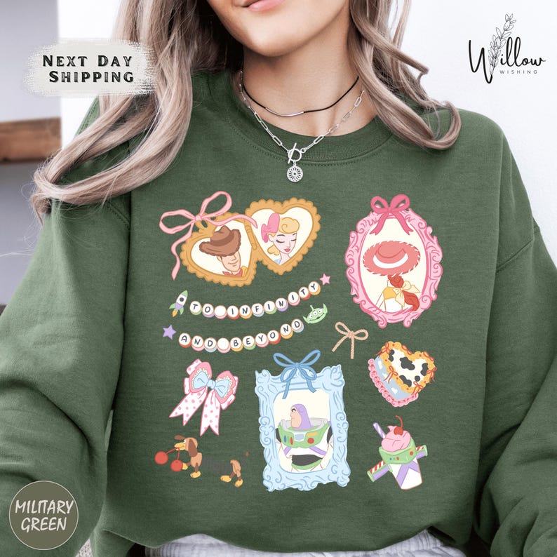 A woman wearing a green sweatshirt with various cartoon-style illustrations and text printed on it.
