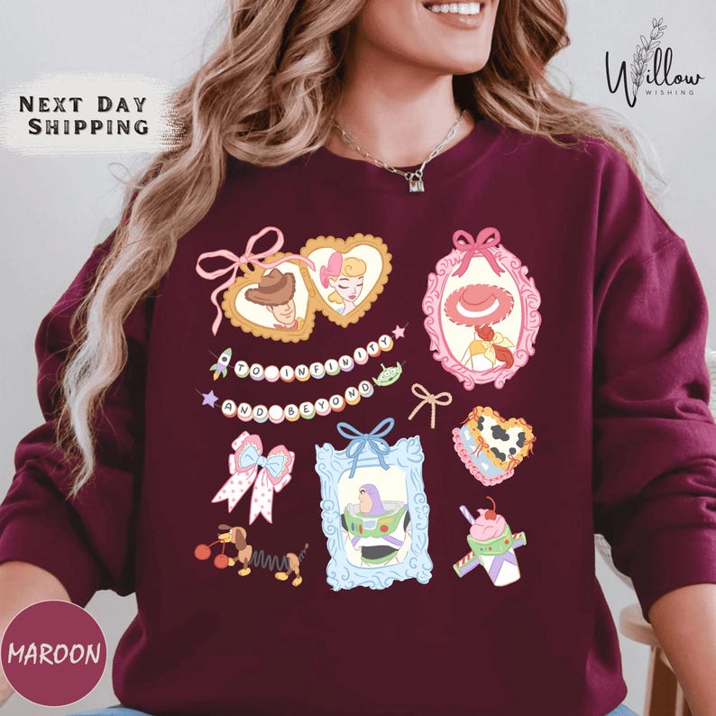 A woman wearing a burgundy sweater with various cartoon-style illustrations and text on it.