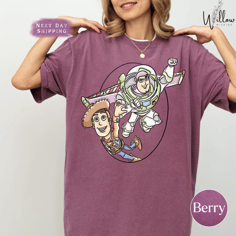 A woman wearing a purple t-shirt with a graphic of Buzz Lightyear and Woody from Toy Story.