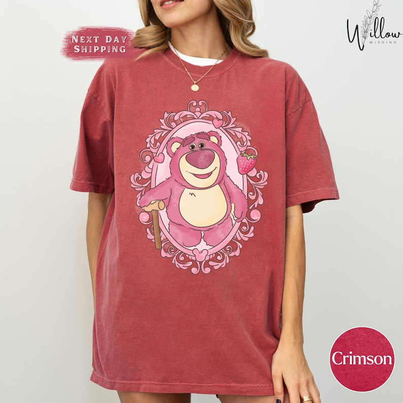 a woman wearing a red shirt with a pink bear on it