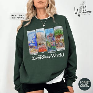 A woman wearing a green sweatshirt with a collage of four Disney World images on it.