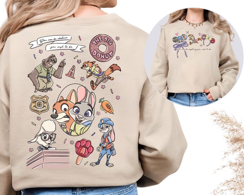 a person wearing a beige sweater with a cartoon-style design depicting various cartoon characters, including a police officer, a rabbit, and other animals.