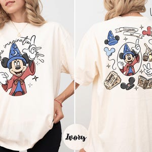 A woman wearing a white t-shirt with a cartoon character and text printed on it.