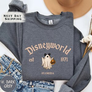 a shirt with a ghost on it next to a hat