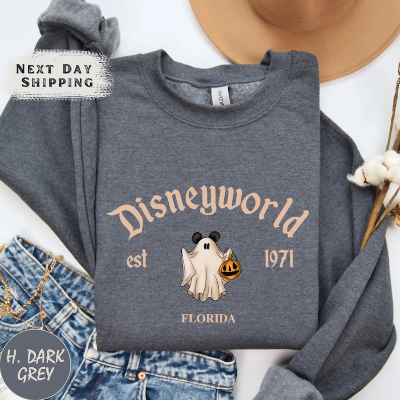 a shirt with a ghost on it next to a hat