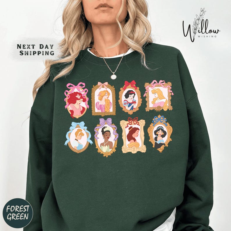A woman wearing a green sweatshirt with a collage of illustrations of Disney princesses.