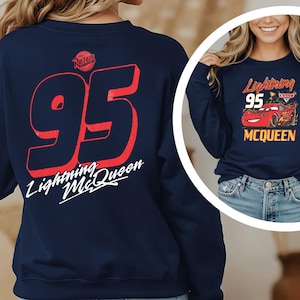 A woman wearing a navy blue sweatshirt with the number 95 and the text "Lightning McQueen" printed on it.