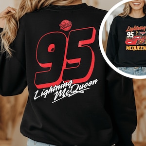 A person wearing a black sweatshirt with a large number 95 and the text "Lightning McQueen" printed on it.