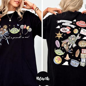 a woman wearing a black t-shirt with various cartoon characters and designs printed on it.