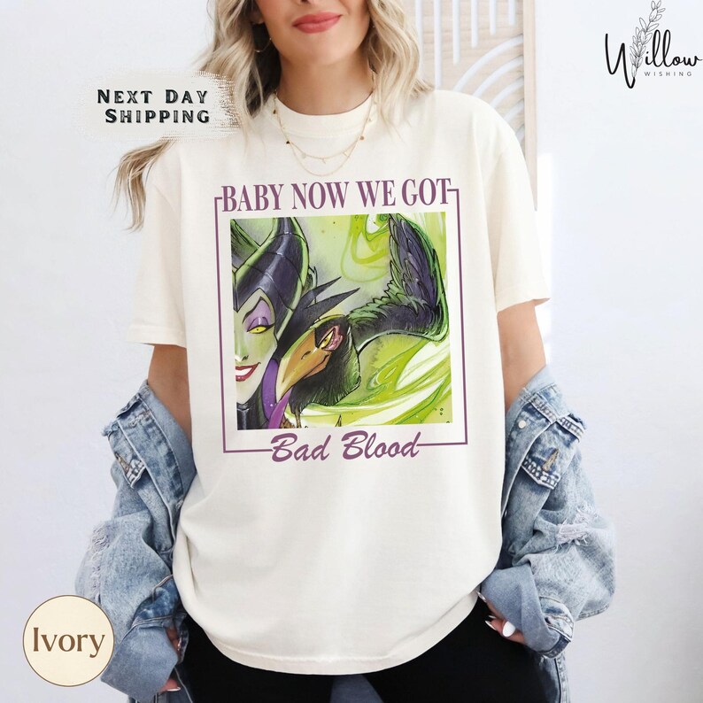 A woman wearing a white t-shirt with a graphic design featuring a character from the Disney movie "Bad Blood".