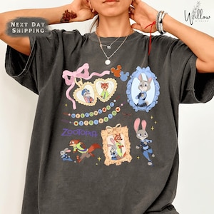 A person wearing a gray t-shirt with various cartoon animal characters and text printed on it.