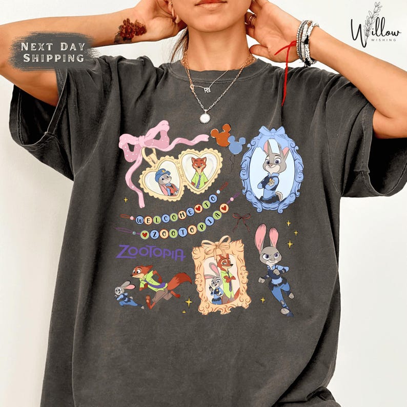 A person wearing a gray t-shirt with various cartoon animal characters and text printed on it.