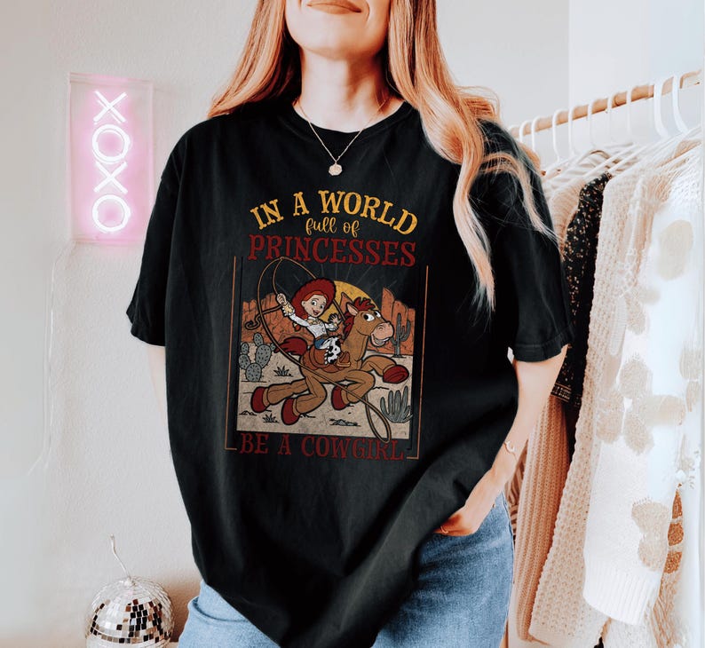 a woman wearing a shirt that says in a world for princesses be a cow