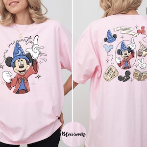 A woman wearing a pink t-shirt with a cartoon character and text printed on it.