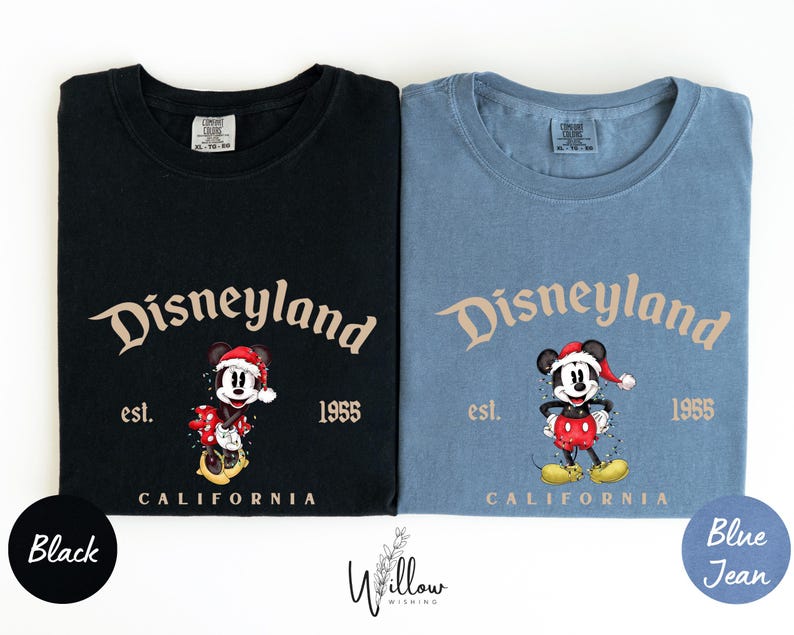 two t-shirts, one black and one blue, both featuring the iconic Mickey Mouse character from Disneyland. The black t-shirt has the text "Disneyland est. 1955" and the blue t-shirt has the text "Disneyland est. 1955".