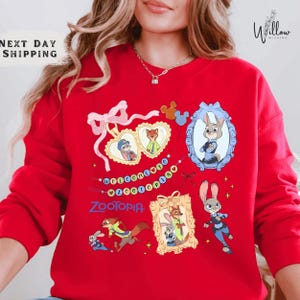 A woman wearing a red sweater with various cartoon animal characters and designs printed on it.
