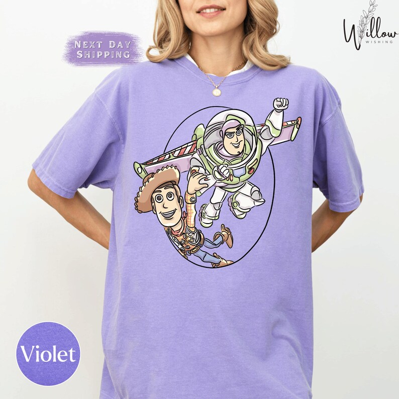 A woman wearing a purple t-shirt with a cartoon image of Buzz Lightyear and Woody from Toy Story printed on it.