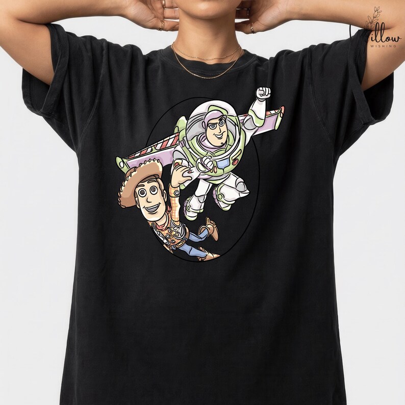 A black t-shirt with a graphic design featuring two cartoon characters from the Toy Story franchise - Buzz Lightyear and Woody.