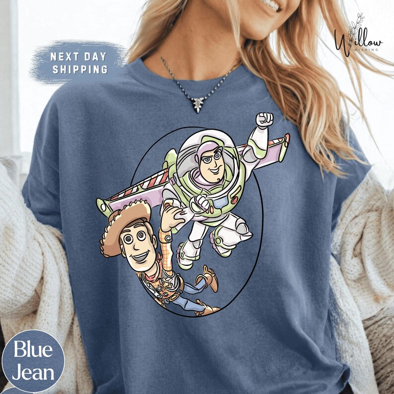 A blue t-shirt with a cartoon illustration of Buzz Lightyear and Woody from Toy Story.