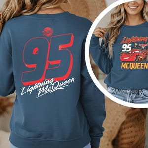A woman wearing a blue sweatshirt with the number 95 and the text "Lightning McQueen" printed on it.
