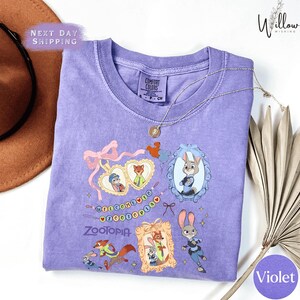 a purple t-shirt with various cartoon animal characters and a purple ribbon, along with a brown hat and a fan.
