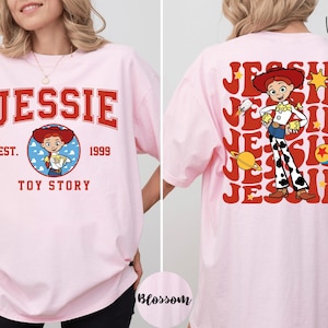 A woman wearing a pink t-shirt with a cartoon character from the Toy Story franchise.