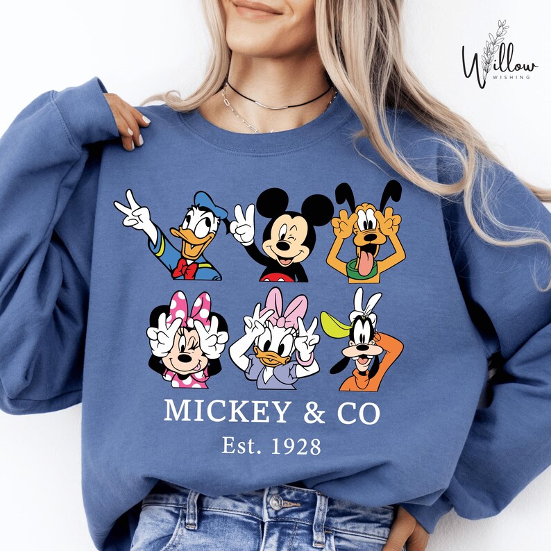 A woman wearing a blue sweatshirt with a graphic of Disney characters Mickey Mouse and Goofy.