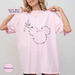 a woman wearing a pink t - shirt with a heart drawn on it
