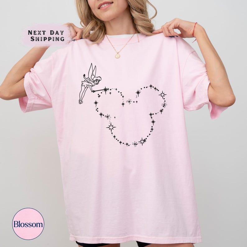 a woman wearing a pink t - shirt with a heart drawn on it