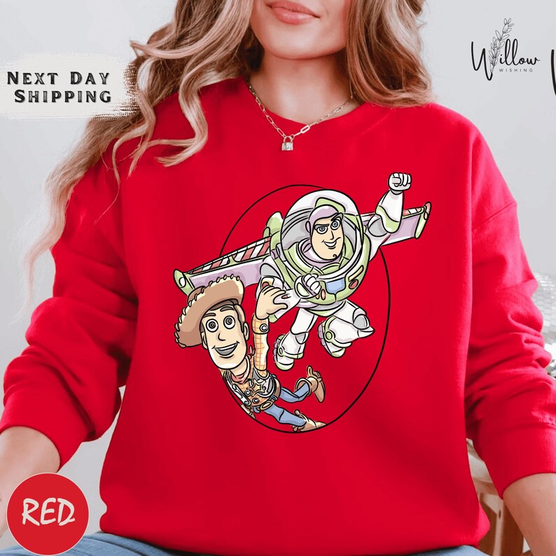 A red sweater with a cartoon image of a character from the Toy Story franchise, specifically Woody and Buzz Lightyear, printed on it.