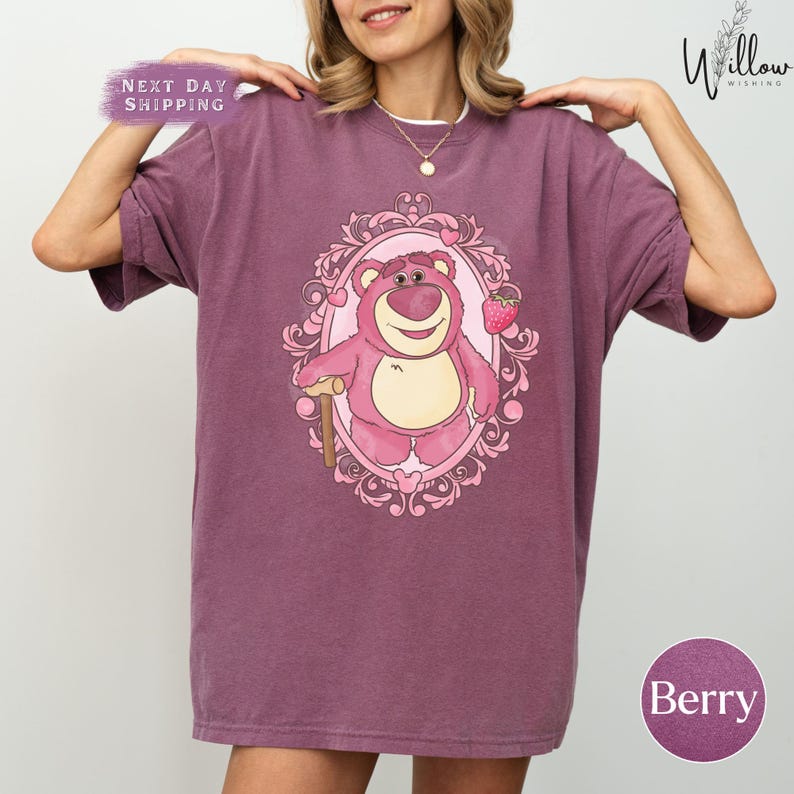 a woman wearing a purple shirt with a bear on it