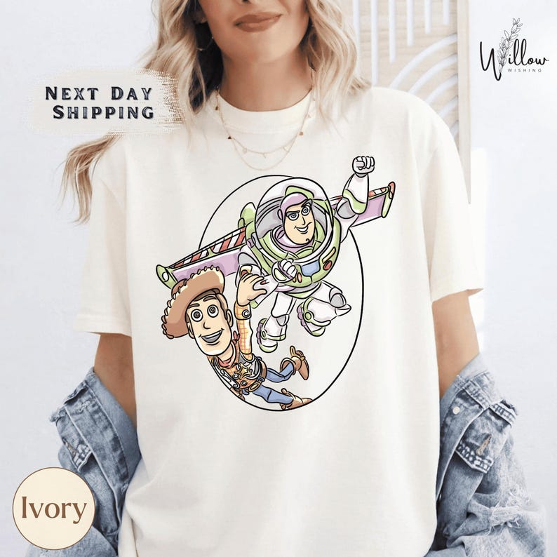 A woman wearing a white t-shirt with a cartoon image of Buzz Lightyear and Woody from Toy Story printed on it.