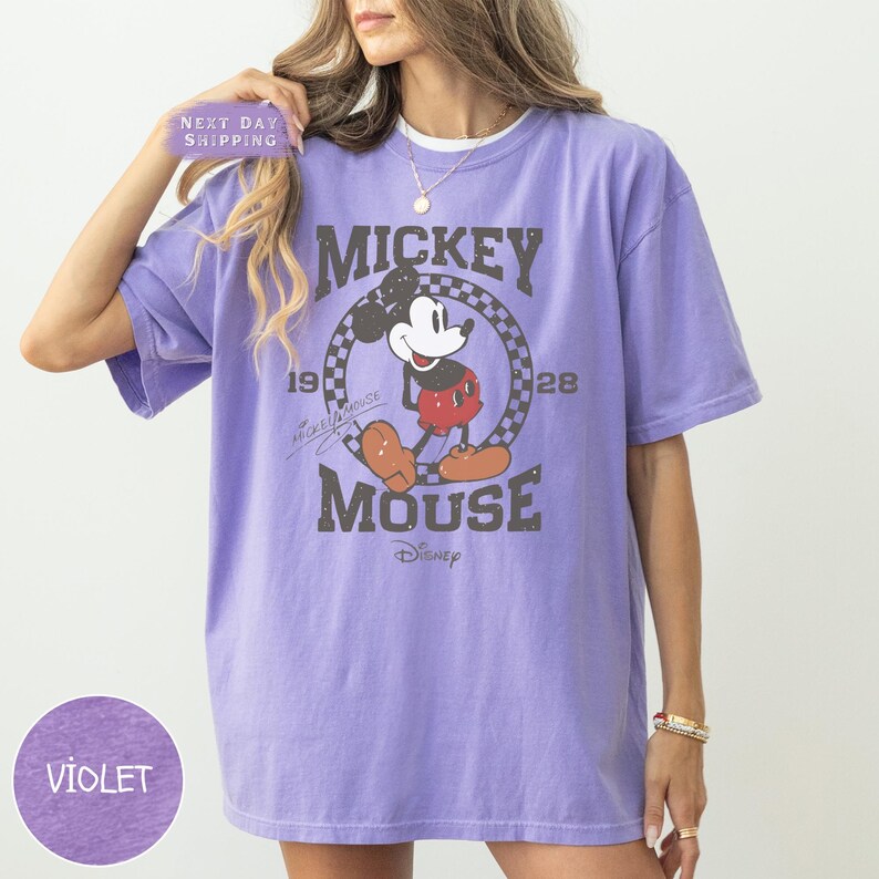 a woman wearing a purple mickey mouse t - shirt
