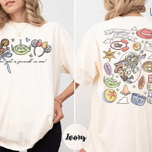 The image is a collage of two images, one showing the front and the other the back of a white t-shirt with a graphic design featuring characters from the Toy Story franchise.