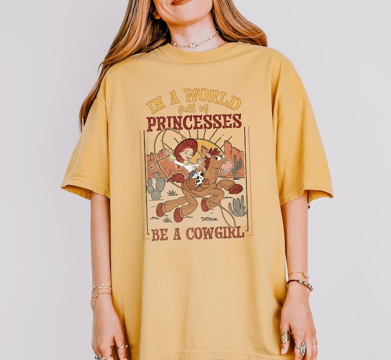 a woman wearing a yellow shirt that says, is a proud princesses be a