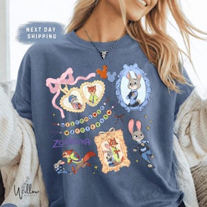 A woman wearing a blue t-shirt with various cartoon characters and designs, including a police officer character.