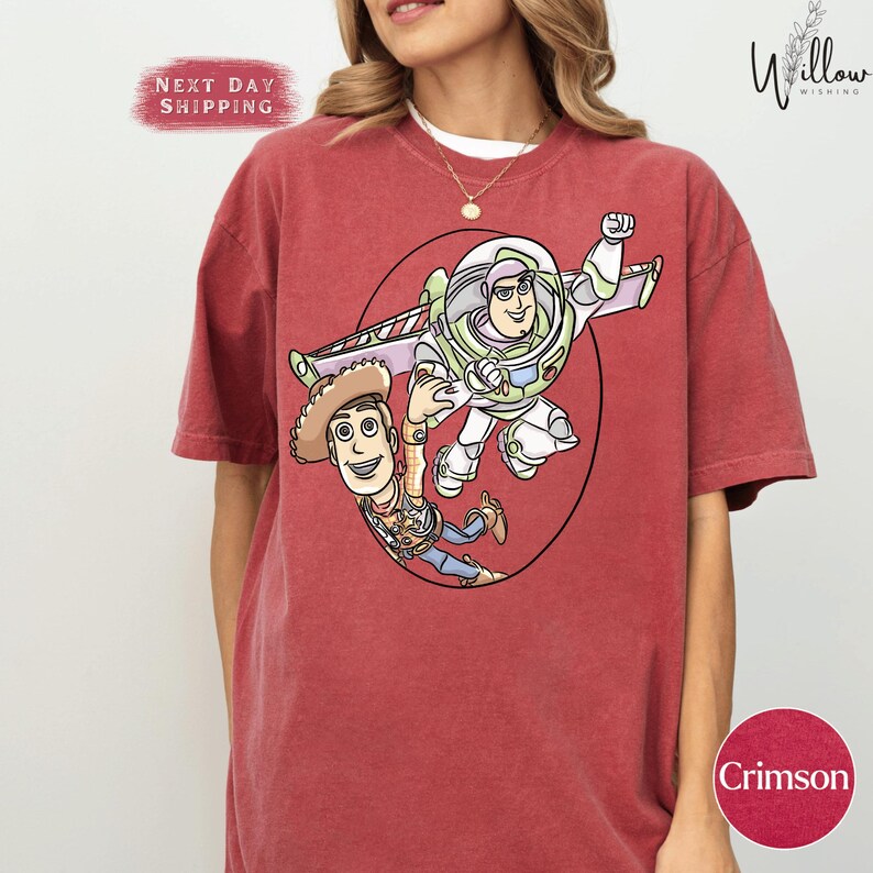A red t-shirt with a cartoon character design featuring a boy and a girl.