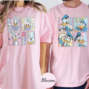 two people wearing pink t-shirts with a collage of cartoon duck images.